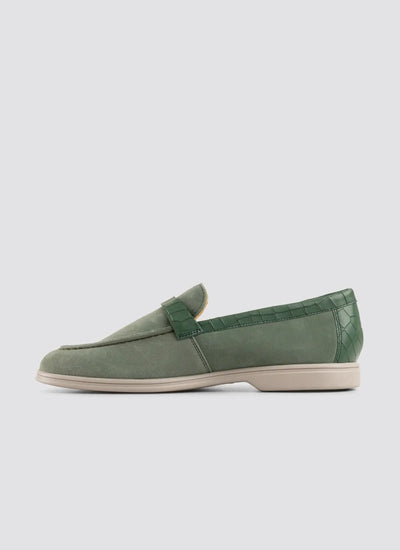 Green loafer shoe on a light gray background 