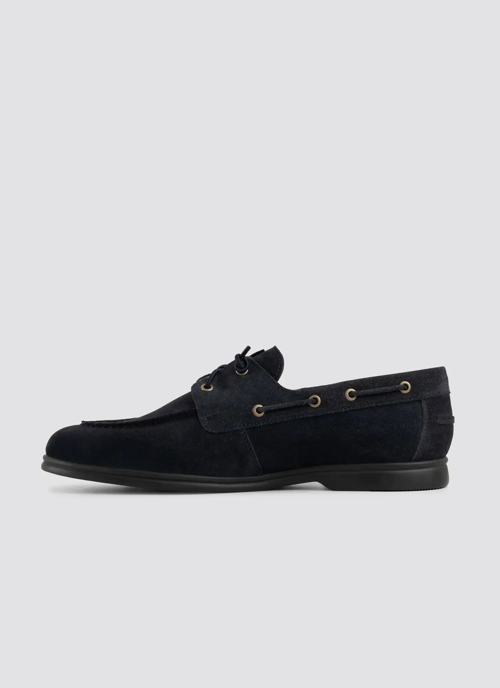 Men's navy suede lace-up loafer with metal eyelets and moc toe on white background.    
