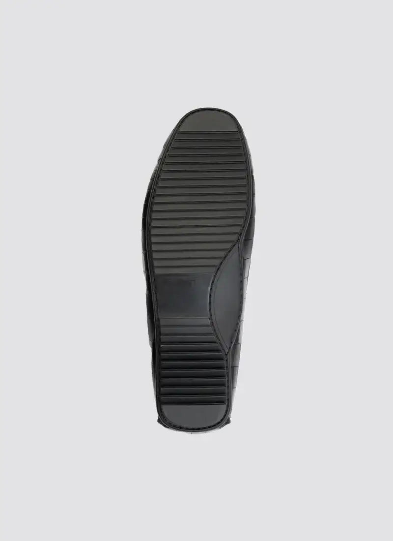 Black shoe sole with textured grip, premium men's footwear, isolated on grey background 