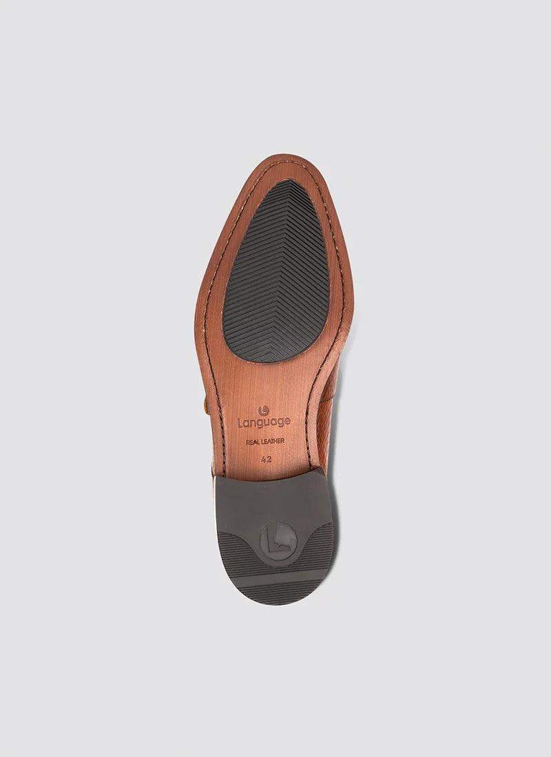 Tan leather dress shoe sole with black rubber grip and visible size marking on a grey background. 