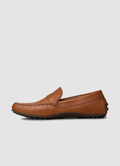 Tan leather loafer for men with moccasin stitching and rubber sole on a plain background 