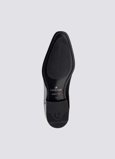 Black formal leather shoe sole with textured grip, viewed from the bottom, on grey background. 