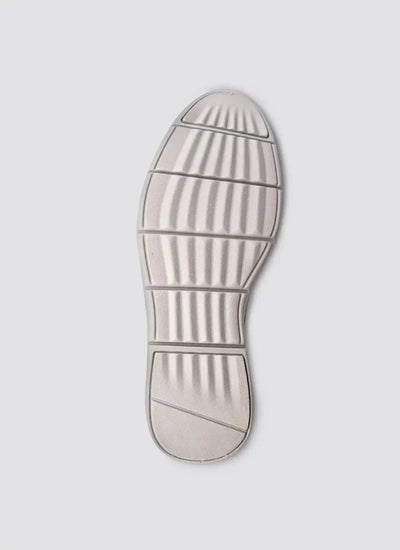 Textured rubber shoe sole with grooved grip pattern on a light grey background 