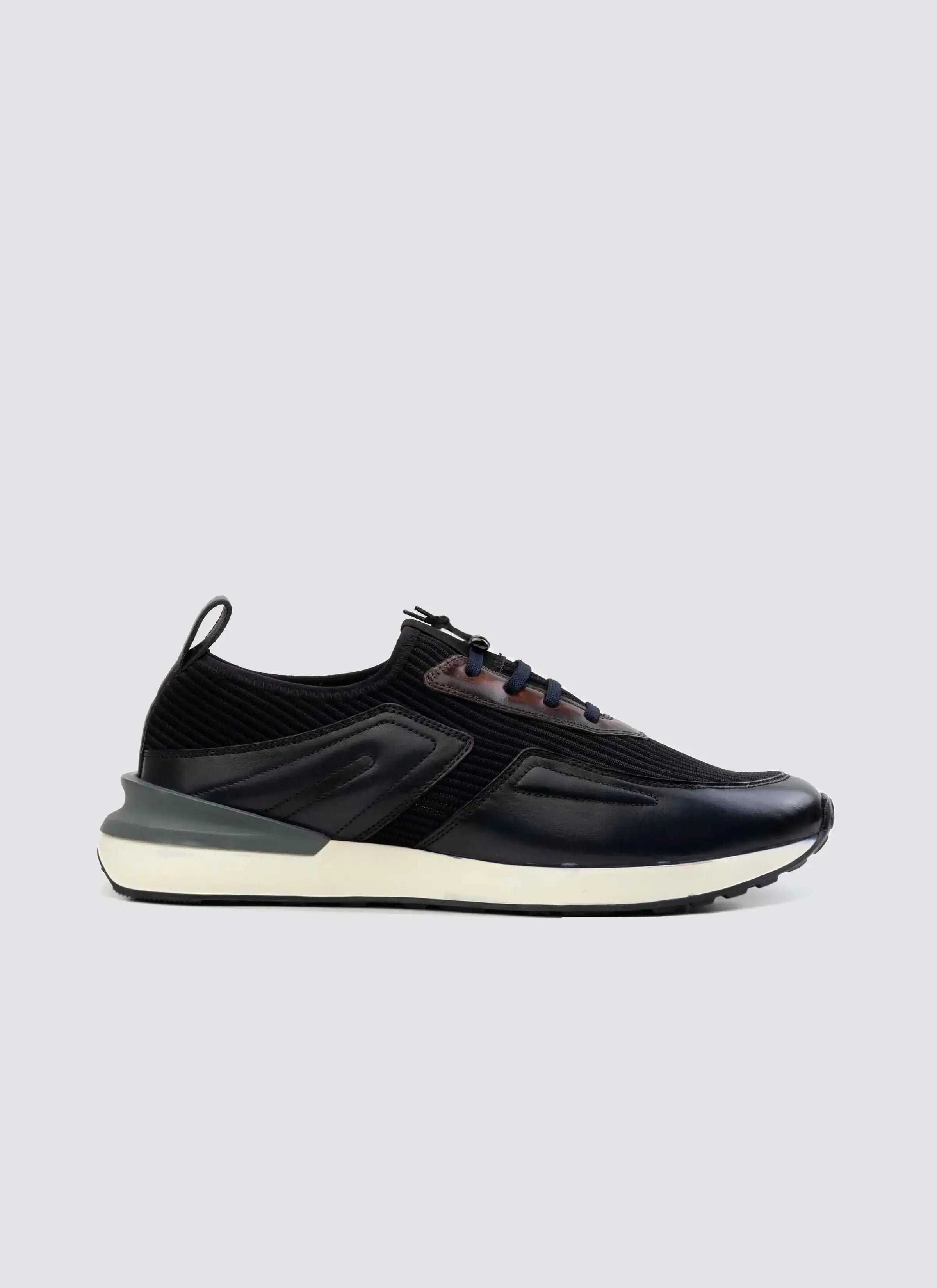 Men's navy casual sneaker with lace-up closure, leather accents, and white sole on plain background 