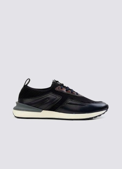 Men's navy casual sneaker with lace-up closure, leather accents, and white sole on plain background 