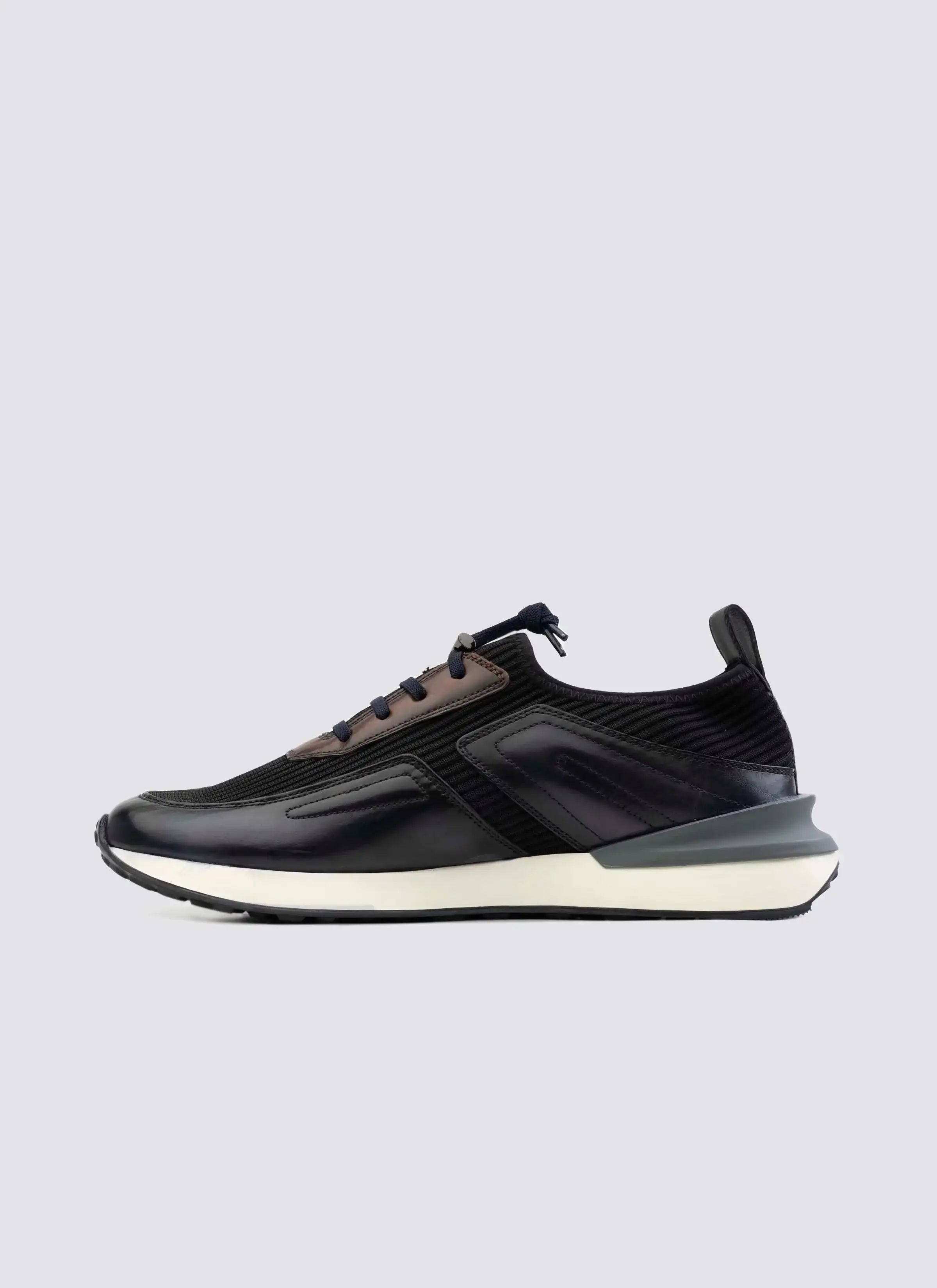 Men's navy blue leather sneaker with white sole, side profile on plain background 