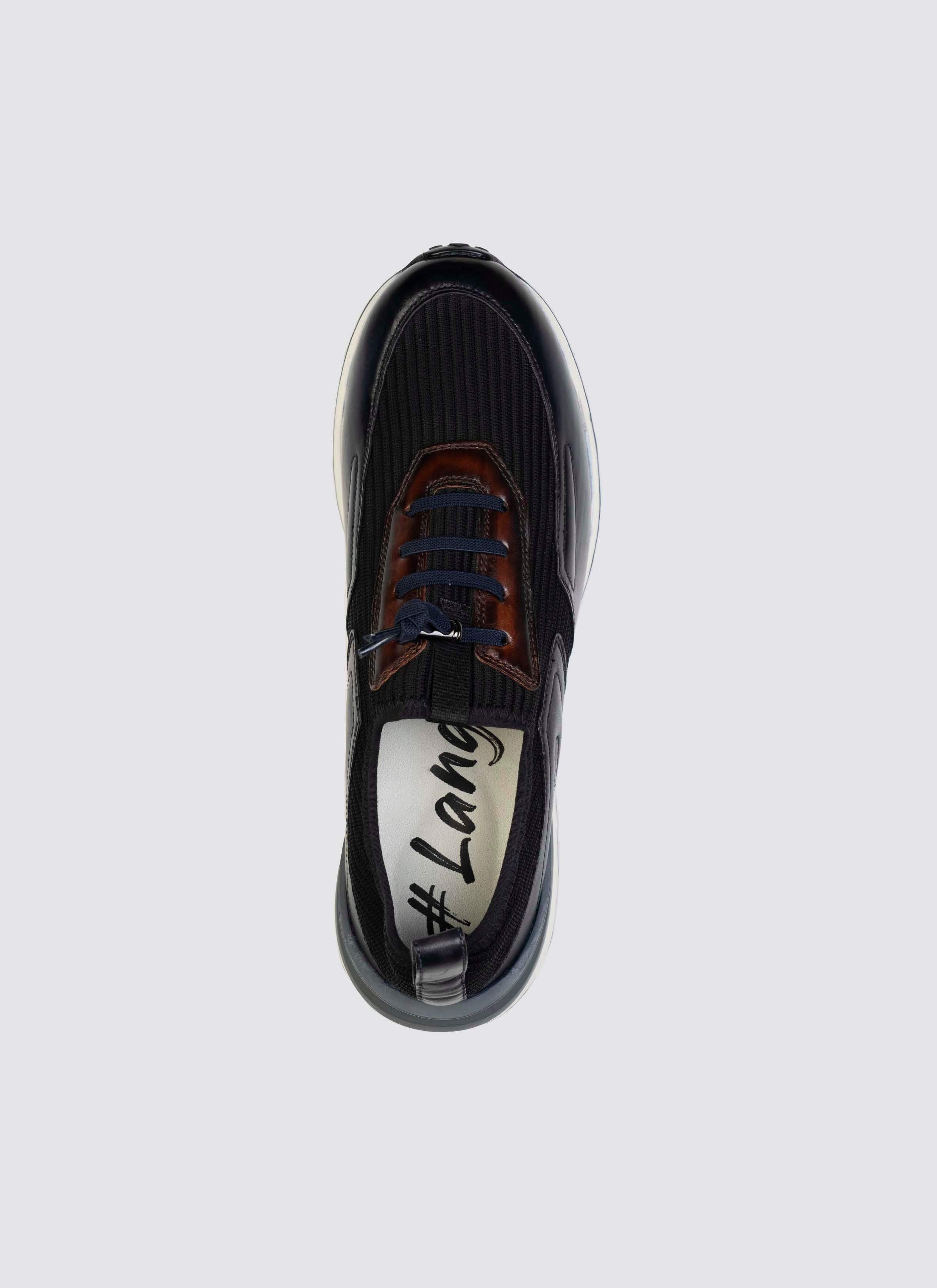 Top view of a navy blue sneaker with brown accents and blue laces on a light background 