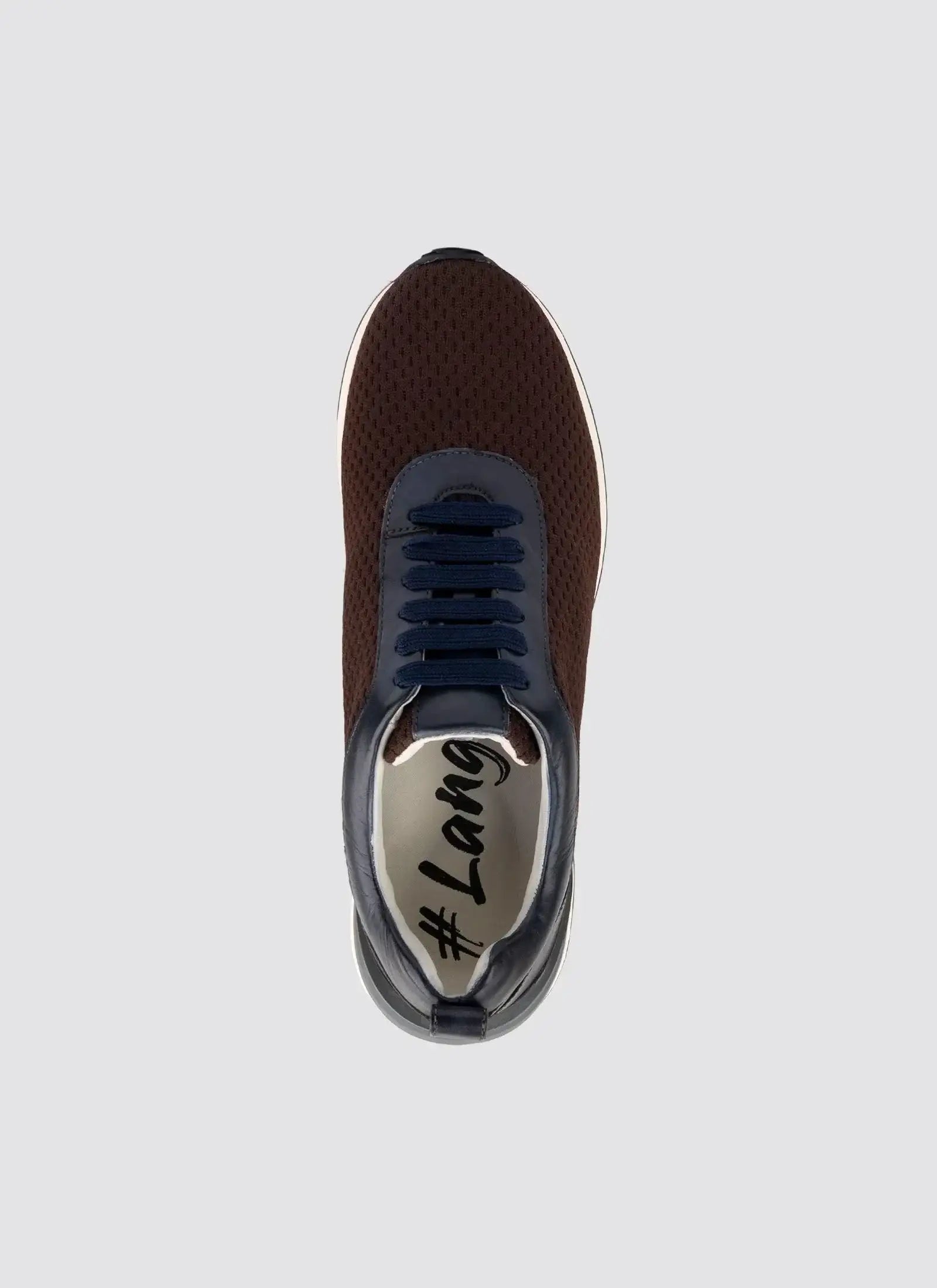 Top view of a brown mesh sneaker with navy laces and white sole on a plain background 