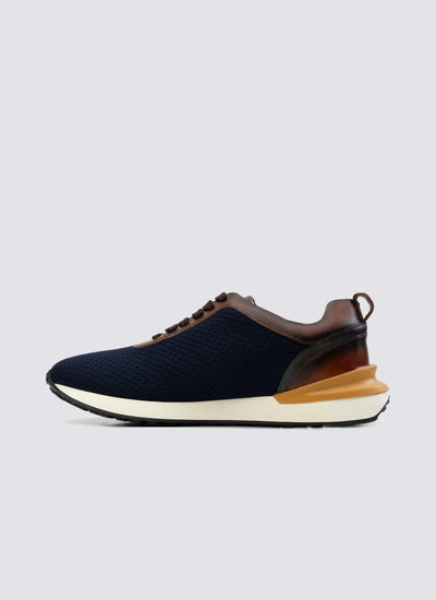 Navy blue mesh sneaker with brown leather accents and white sole, side view on plain background 