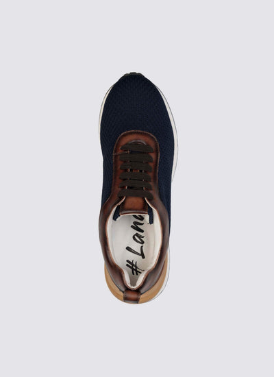 Top view of a navy blue sneaker with brown leather accents, white sole, and black laces. 