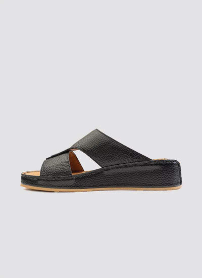 Black leather slide sandal with criss-cross straps and flat tan sole for men or women 