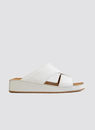 White leather slide sandal with cross-strap design and flat sole on a plain background 