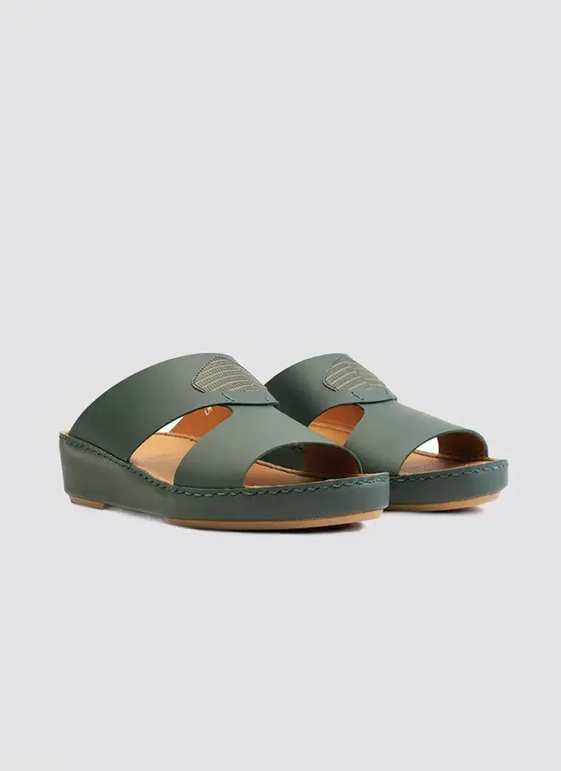 Green leather slip-on sandals with open toe and cushioned tan footbed on plain background 