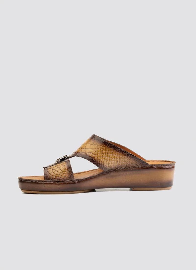 Tan brown textured leather slip-on sandal with low wedge sole on white background