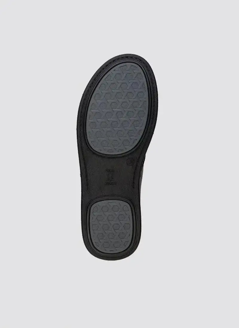 Black shoe sole with textured grip pattern on a plain background 