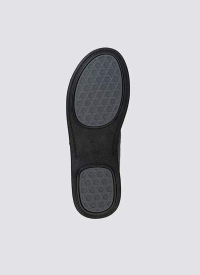Black shoe sole with textured hexagonal grip design on a light background 