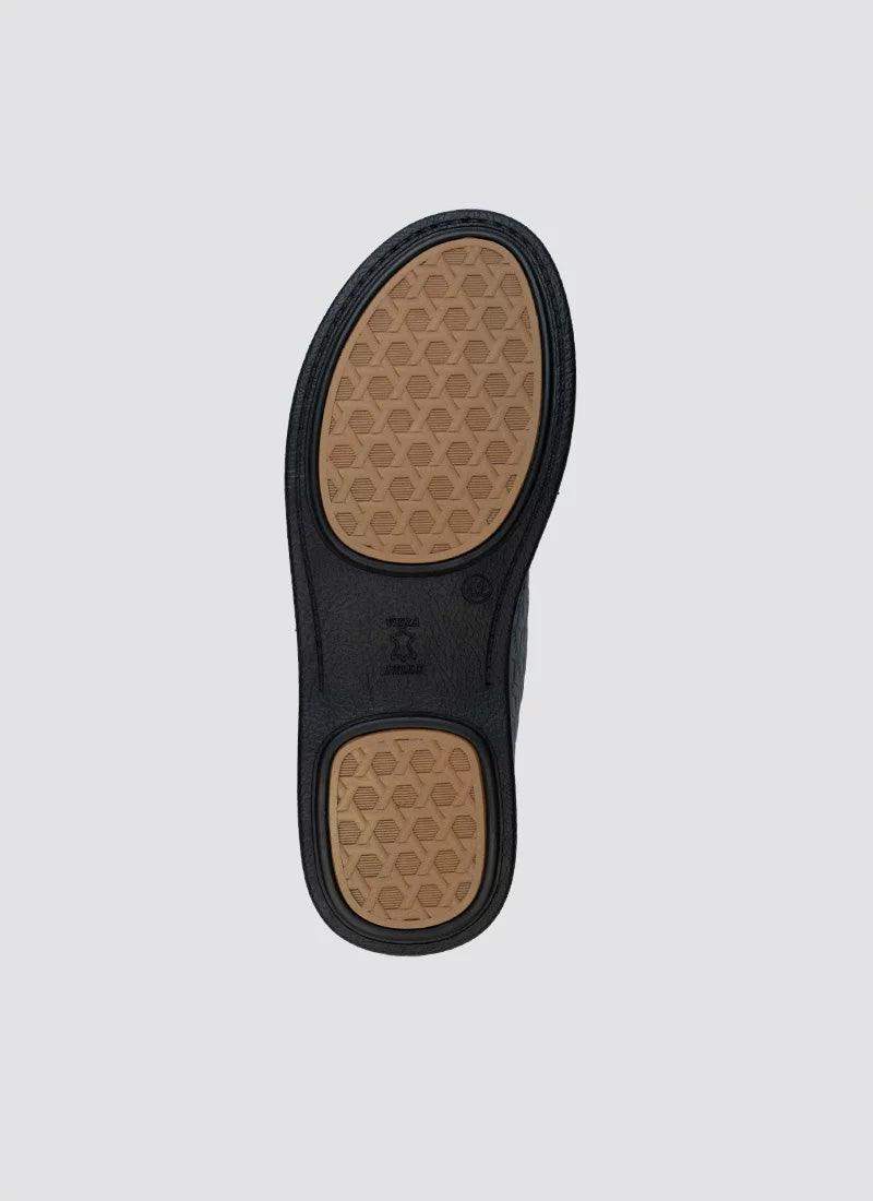 Close-up of a men's shoe sole with textured rubber grip and brown tread pattern 