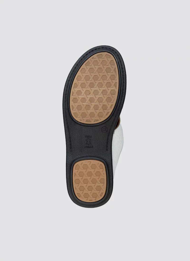 Close-up of brown textured rubber shoe sole with black trim on white background 