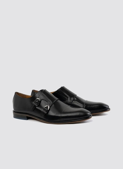 Black leather double monk strap dress shoes for men on a plain background 