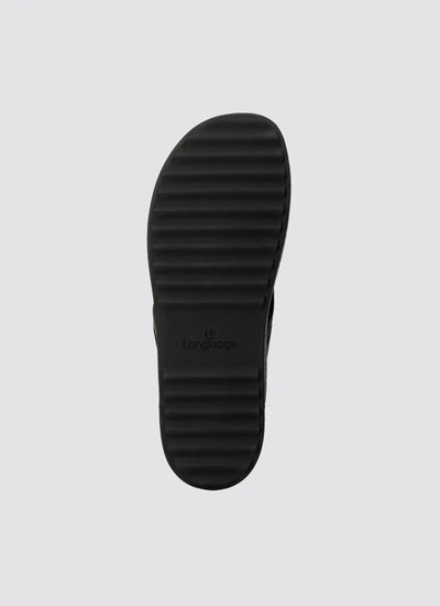 Black ridged rubber shoe sole with horizontal grooves on light background 