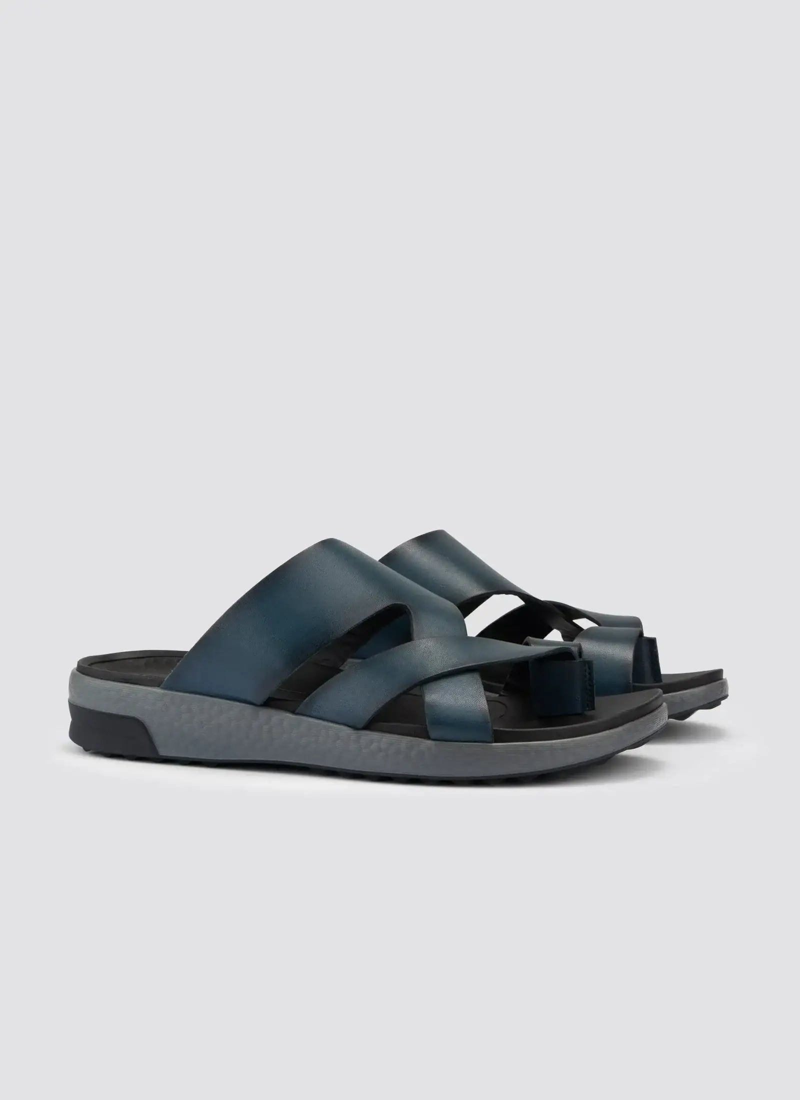 Navy blue men's leather slip-on sandals with crisscross straps and a textured sole #color_navy