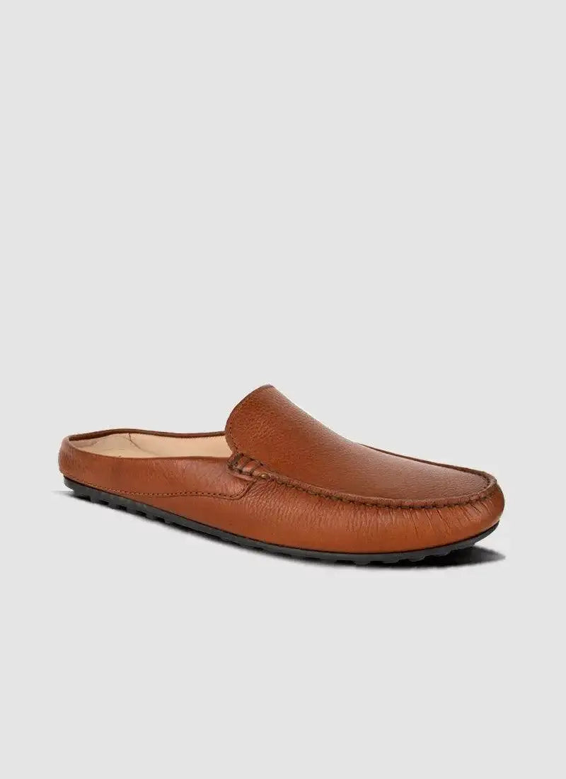Tan leather men's loafer mule with textured upper and rubber sole on light background 