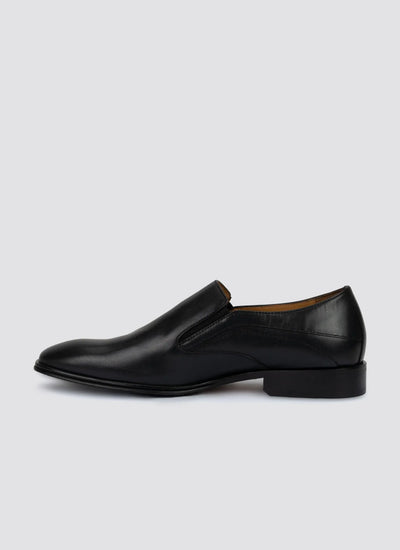 Men's black leather slip-on loafer with low heel and rounded toe on light background 