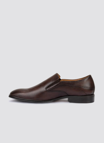 Men's brown leather slip-on dress shoe with low heel on white background 