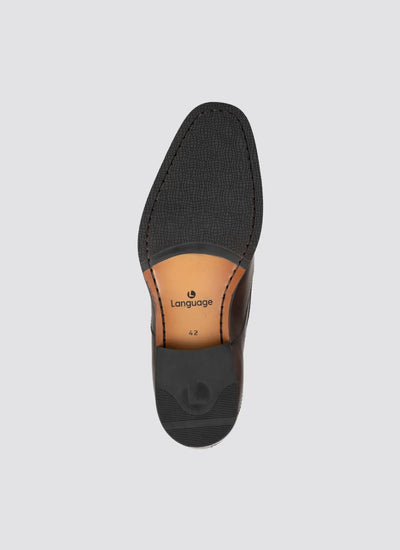 Close-up of a brown leather men’s dress shoe sole with textured black tread and size details.