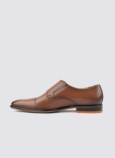 Men’s tan leather slip-on dress shoe with cap toe and low heel on white background 