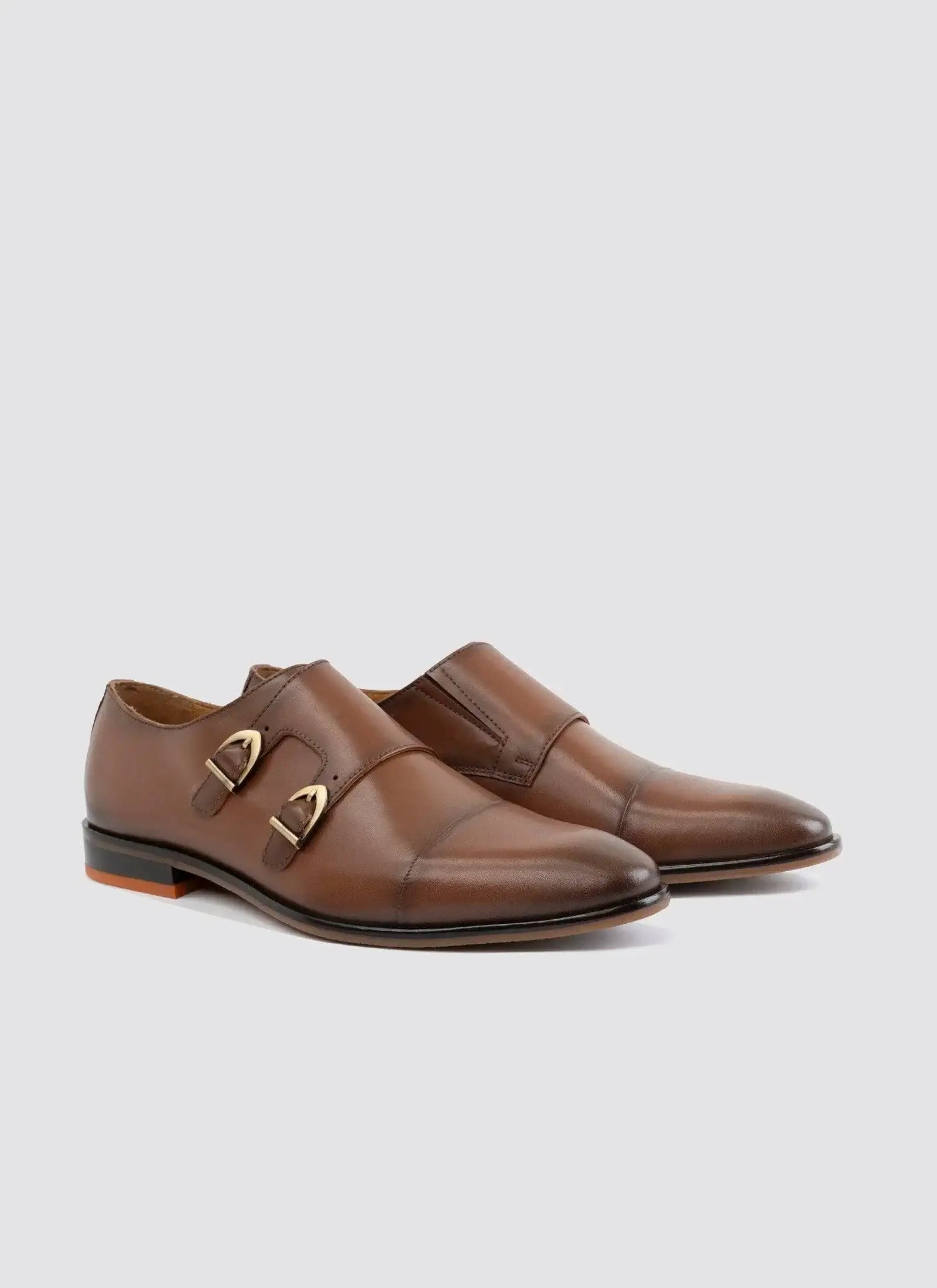 Men's brown leather double monk strap dress shoes with gold buckles on white background  