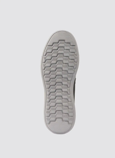Grey rubber shoe sole with textured, non-slip tread pattern on white background 