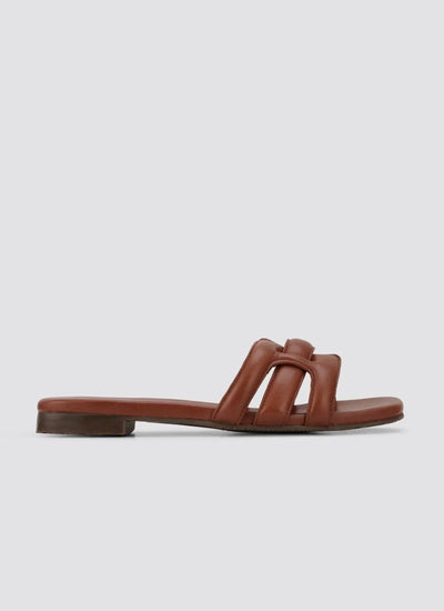Tan brown leather flat slide sandal with cushioned straps, side view on white background 