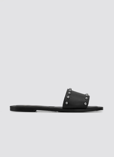 Black flat slide sandal with metal stud accents on the strap, side profile on white background 