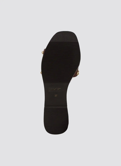 Black rubber sole of a women's cognac sandal, size 37, with gold accents on sides 