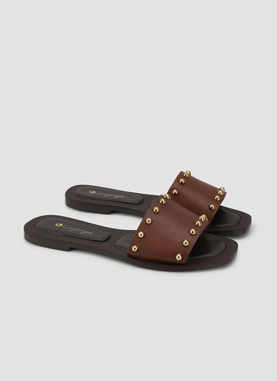 Brown leather flat sandals with gold stud accents, open toe, and cushioned sole 