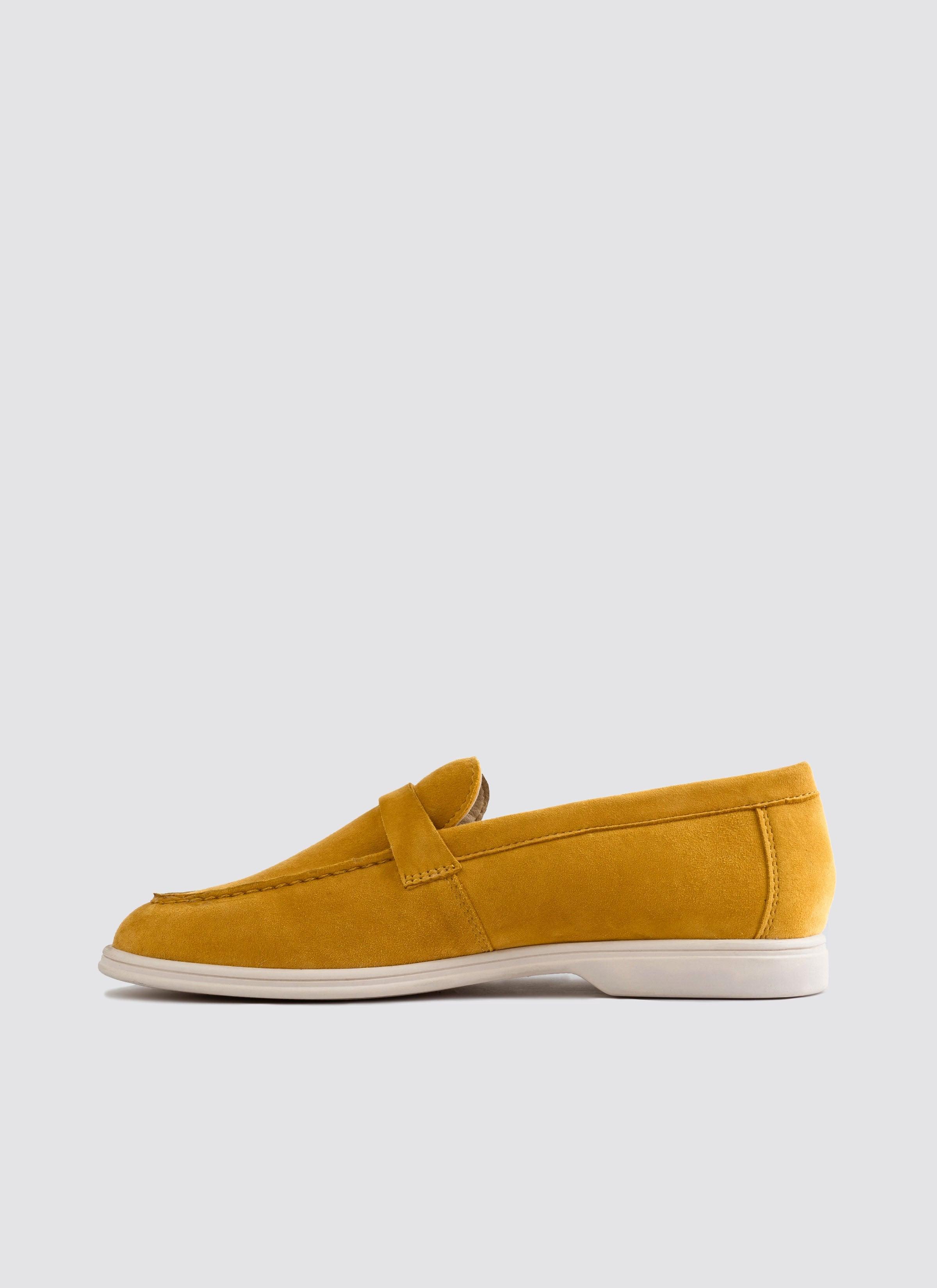 Mustard yellow suede loafer with white sole, classic men's footwear on white background  
