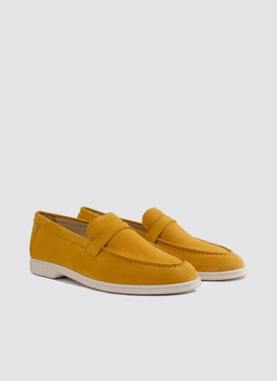 Pair of mustard yellow suede loafers with white soles for men on plain background  