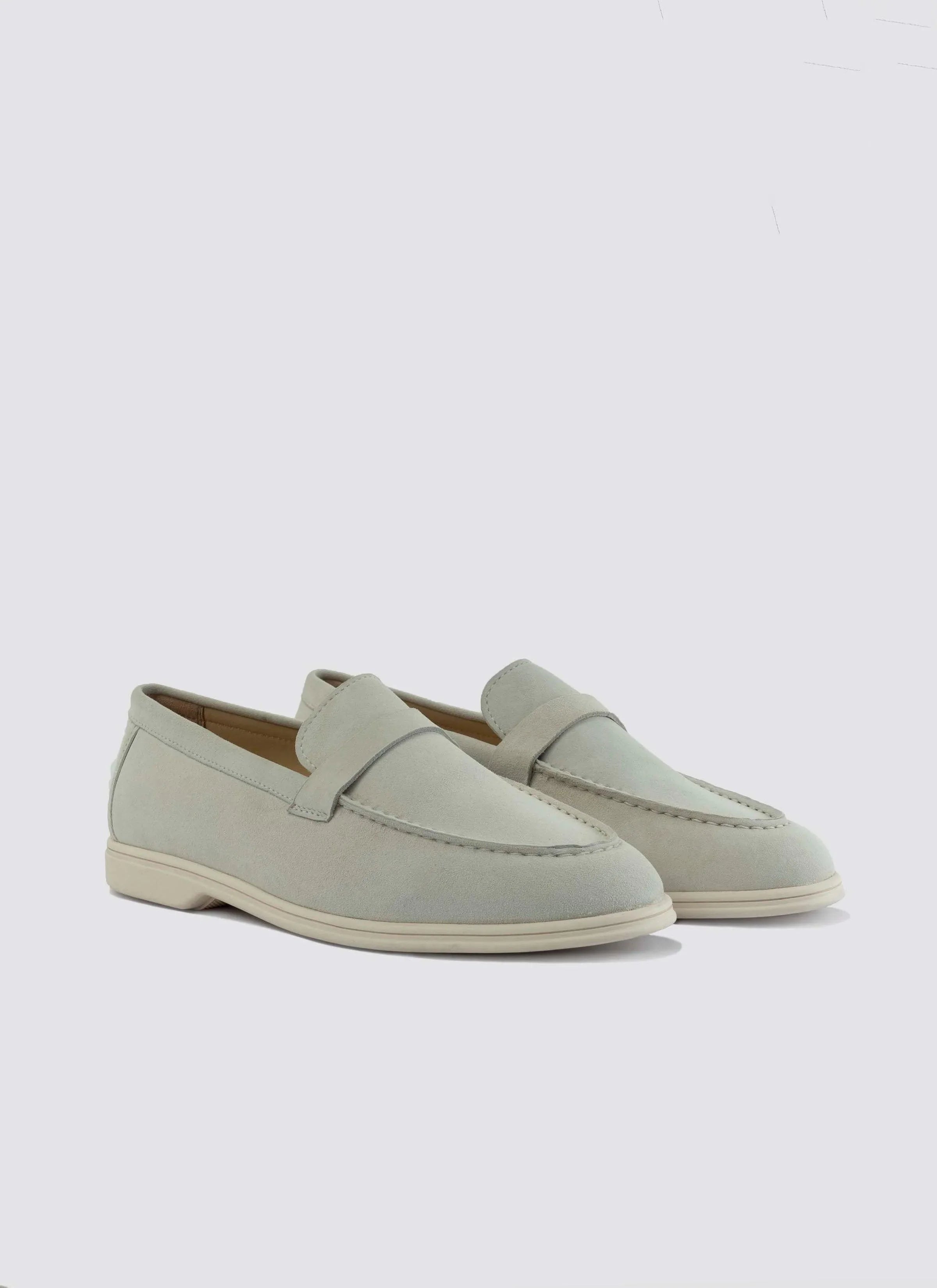 Men's off-white suede loafers with slip-on design and stitched detailing on white background 