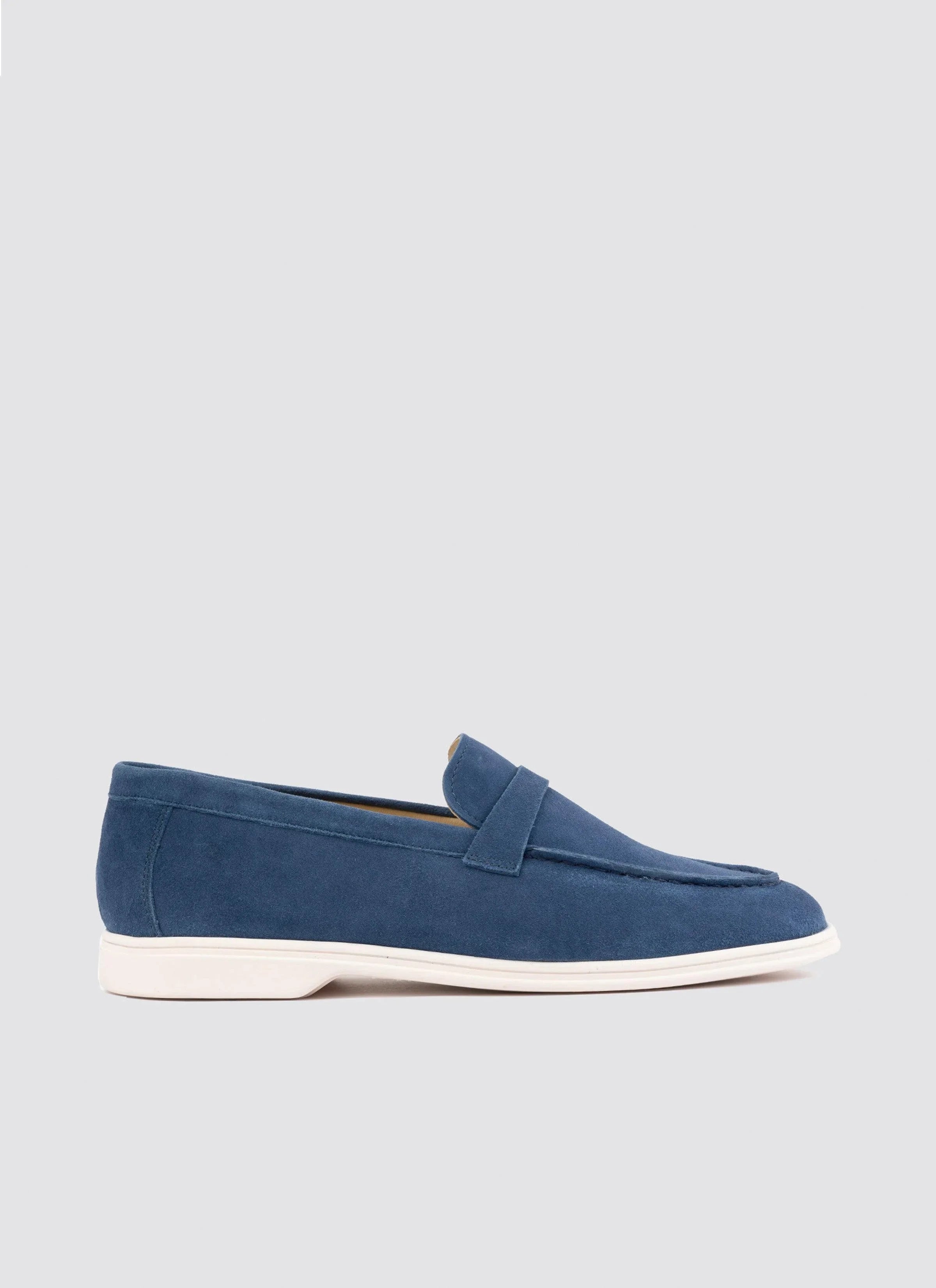 Men's navy blue suede loafer with white sole on plain background  
