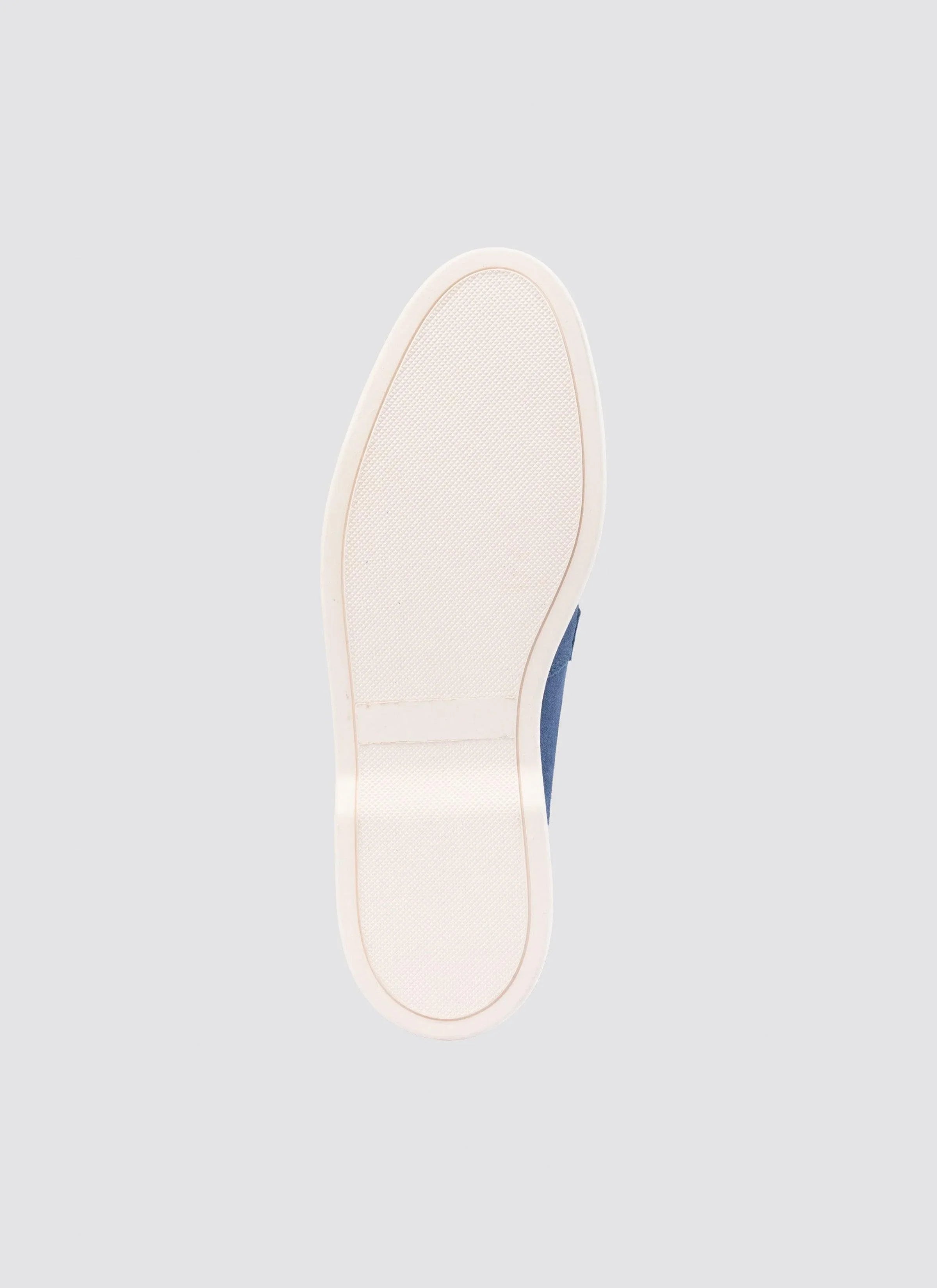 Close-up of rubber sole of a navy blue casual shoe on light grey background 