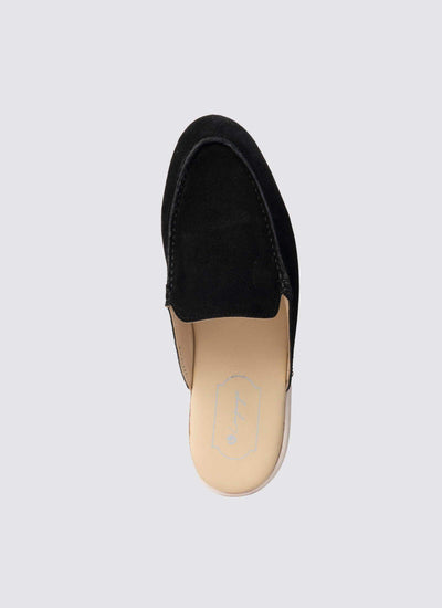 Top view of a black suede slip-on loafer with beige insole on a plain background. 