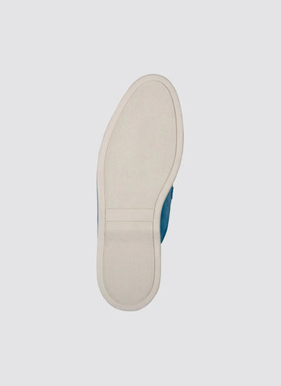Close-up of a white rubber sole on a blue casual shoe, viewed from the bottom. 