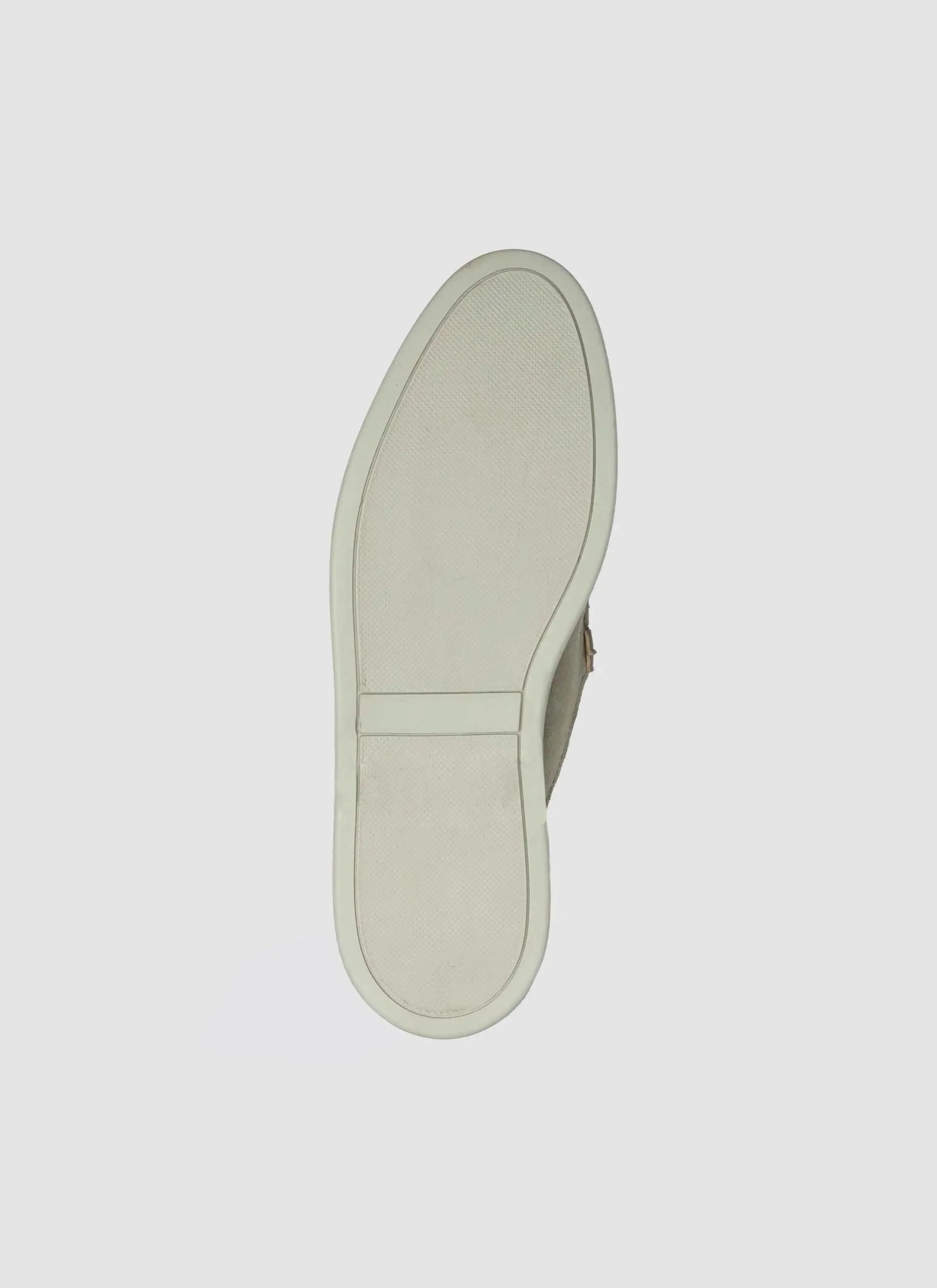 Close-up of light olive sneaker sole with textured grip, set on a white background 