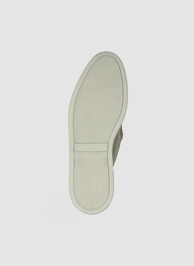 Close-up of light olive sneaker sole with textured grip, set on a white background 
