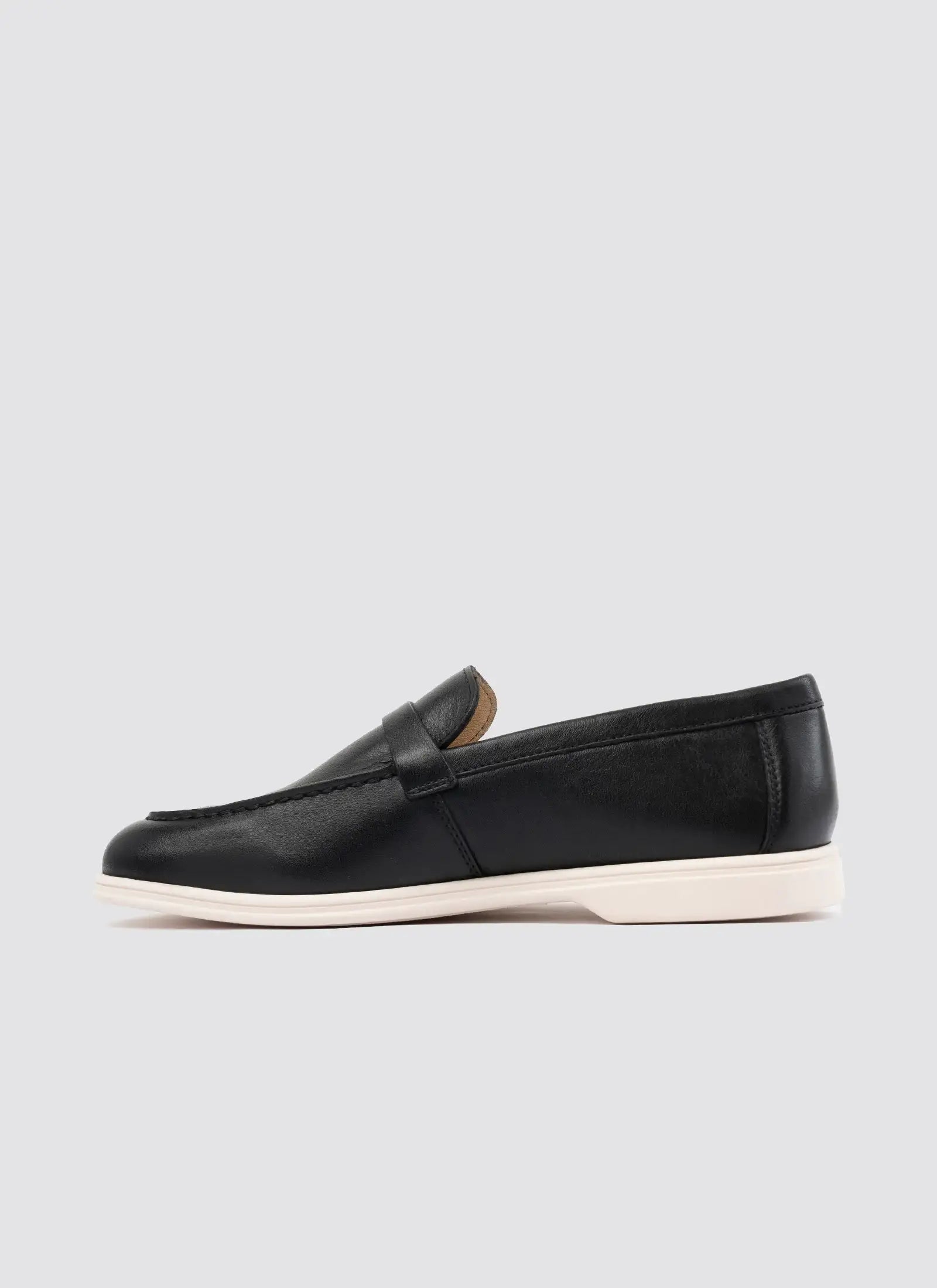 Black loafer shoe on a light gray background 