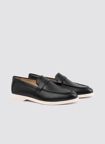 Pair of black loafers on a light gray background 