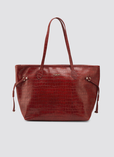 Red leather handbag with a textured pattern on a light gray background 