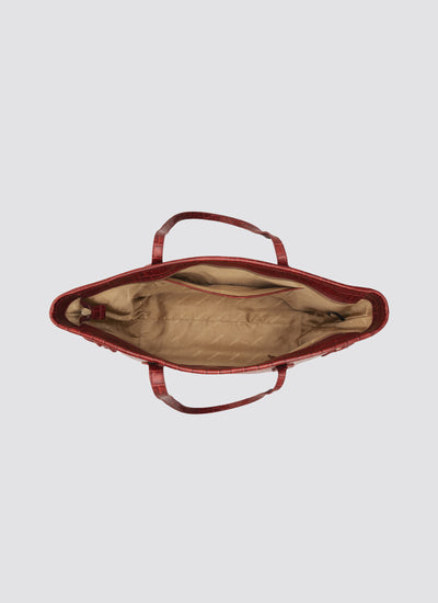 Red handbag with open lid on a light gray background 