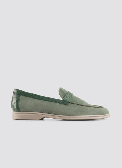 Green loafer shoe on a light gray background 